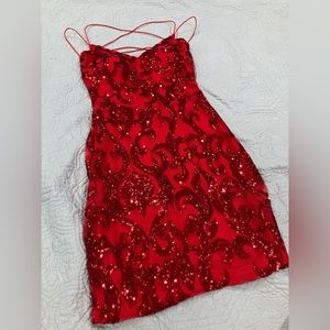 Small, red dress w/ sequence design, V neck, open cross tie back, zipper.